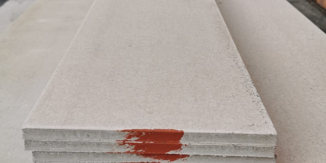 Stack of light gray concrete slabs with a red paint stain on the front edge.